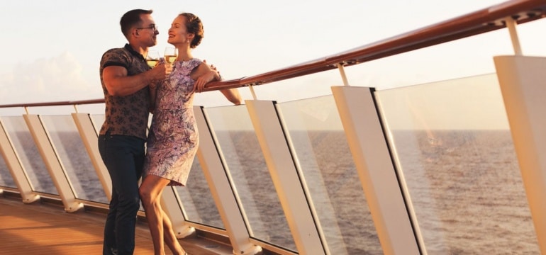 couple standing with glasses white wine on cruise ship